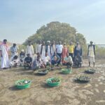 Conservation partners and local community members assembled beside mangrove seedlings at a restoration site in Dungonab Bay and Mukkawar Island Marine National Park.